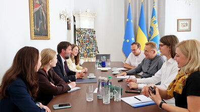 міський голова Львова Андрій Садовий, посадовці міської ради та представники Cowater International розмовляють за столом.