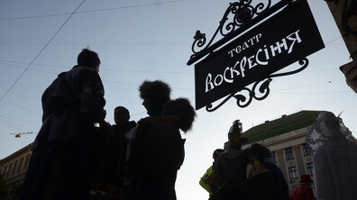 Люди йдуть площею Генерала Григоренка. Зверху видно вивіску з написом 