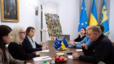 Міський голова Львова Андрій Садовий спілкується із Сесілією Далман Ек під час зустрічі у Львівській міській раді. За столом сидять інші учасники зустрічі, перед ними — прапорці України та Ради Європи