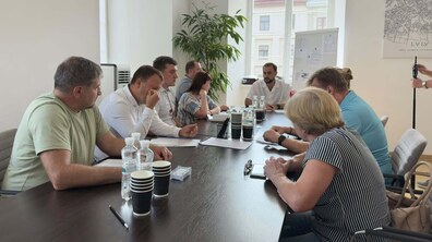 У кабінеті за столом сидить керуючий справами виконкому Євген Бойко, місцеві мешканці площі Ринок та представники ресторану McDonald's. Під час спілкування обговорюють усунення шуму та запаху біля їхніх помешкань