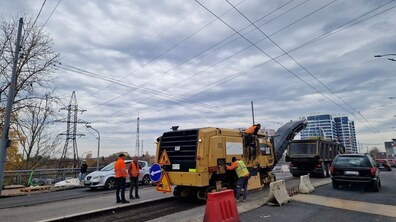 по центру моста на вул. Кульпарківській ремонтна бригада знімає асфальтне покриття