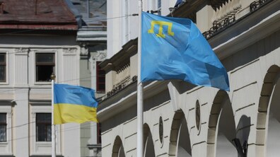 Два прапори, що майорять на флагштоках біля будівлі львівської Ратуші: на передньому плані – кримськотатарський прапор (блакитний прапор із жовтою тамгою – традиційний символ кримських татар), позаду – прапор України (синьо-жовтий).