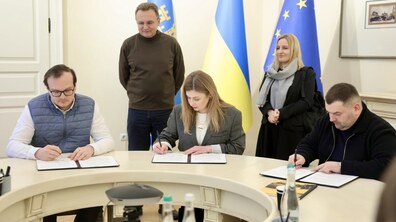 Анастасія Образцова, директорка Українського культурного фонду, Андрій Москаленко, перший заступник міського голови та Андрій Закалюк, очільник департаменту освіти та культури ЛМР сидять за столом та підписують меморандум. Позаду стоять міський голова Андрій Садовий та Юлія Хомчин, директорка Інституту стратегії культури, лідерка заявки Львова на титул ЄСК 2030