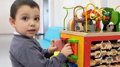 Хлопчик грається великою іграшкою з різними комірками та розвиваючими елементами у лікарні святого Миколая Першого медоб’єднання Львова