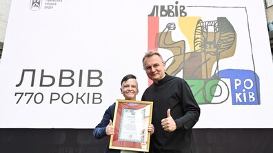11-річний Роман Олексів, який вижив після ракетного удару по Вінниці, разом з мером Львова Андрієм Садовим у дворику Ратуші. Роман тримає в руках подяку від міста, позаду великий банер до 770-річчя Львова.