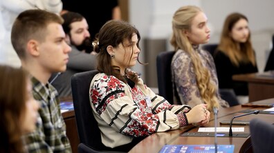 Учасники Школи громадянського лідерства «Небайдужі» слухають виступ спікера у сесійній залі Львівської міської ради; на передньому плані — дівчина у білій вишиванці з червоно-чорним орнаментом