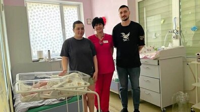 батьки немовляти разом із медичною працівницею в палаті неонатального відділення