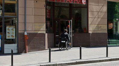 Фото ілюстративне. Чоловік на кріслі колісному заходить в приміщення книгарні.