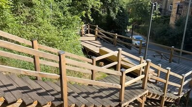 Дерев’яні сходи у парку «Знесіння», які змійкою розташовані серед зеленої гущавини дерев.