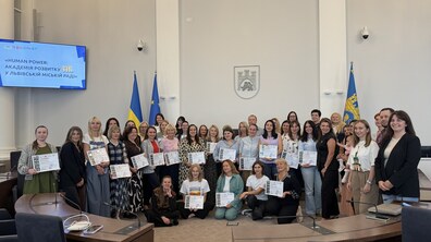 Спільне фото учасників Академії розвитку HR та організаторів у великій сесійній залі Львівської мерії. Учасники усміхаються та тримають у руках сертифікати.