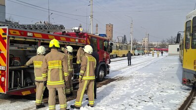 Студенти Львівського державного університету безпеки життєдіяльності у захисному спорядженні проводять практичне заняття біля пожежної машини на території трамвайного депо.