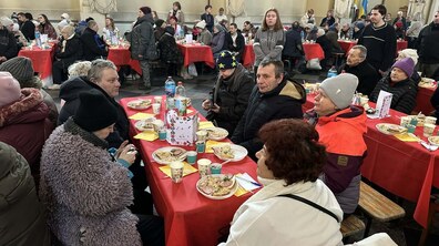 Люди сидять за святковим столом, на якому є різні страви