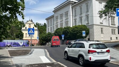 вулиця Винниченка після ремонту. Новою асфальтованою дорогою їдуть автомобілі. Обабіч облаштовані широкі тротуари з пониженими бордюрами та пішохідними переходами. Біля дороги видно дорожні знаки та припарковані авто.