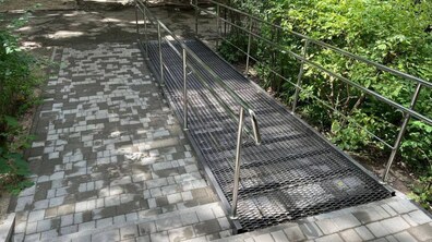 Фото: У будинку на вул. Науковій, 26 облаштують три металеві пандуси для людей на кріслах колісних: два уже встановили