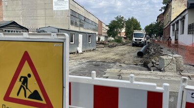 Триває ремонт на вул. Залізничній. На передньому плані видно дорожнє огородження зі знаком «Дорожні роботи». За ним — розрита вулиця. Вздовж дороги прокладені великі чорні труби.