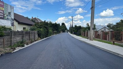 Відремонтована ділянка вул. Тракт Глинянський. Уздовж приватної забудови простягається свіже асфальтове покриття без автомобілів і пішоходів. Обабіч дороги облаштовані нові бордюри та тротуари з плитки.