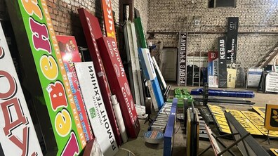сотні демонтованих вивісок, які тимчасово зберігають на складі