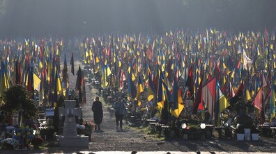 Безліч синьо-жовтих та червоно-чорних прапорів височіють над могилами українських захисників на Полі почесних поховань.