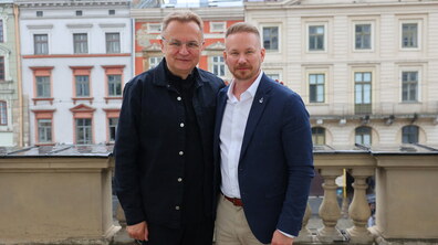 Міський голова Львова Андрій Садовий з генеральним директором Business Tampere Харрі Оджала на балконі Львівської міської ради. Позаду на фоні кольорові львівські кам'яниці