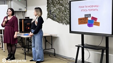 дві соціальні працівниці показують презентацію на великому екрані