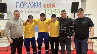 Студенти у жовтих футболках та темних штанах роблять фото разом із своїми наставниками. Позаду - банер із написом Install Fest Покажи свій талант.