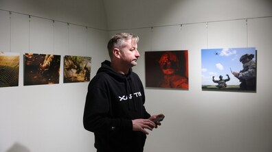 Сергій Жадан у Музеї міста. Навколо нього розташовані світлини фотовиставки