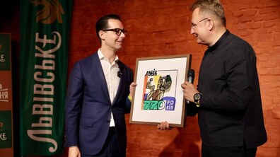 Міський голова вручає СЕО Carlsberg подарунок в честь 770-річчя Львова. У рамці зображено логотип міста, розроблений спеціально до святкування ювілею.
