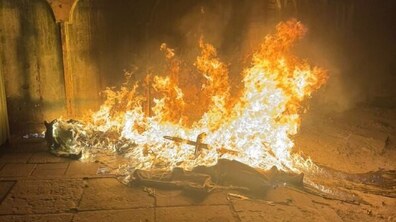 Контейнерний майданчик на вул. Левандівська, 23 під час займання — горить полум’я, яке піднімається вгору і частково освітлює простір довкола. Вогонь виглядає інтенсивним. Поруч видно темні, обгорілі елементи.