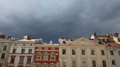 Небо темно-синього кольору з грозовими хмарами нависає над будинками у центрі міста