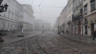 Вкрита густим туманом площа Ринок, здалеку ледь помітні силуети перехожих.