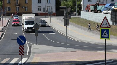 Автівки їдуть дорогою, яка впирається в острівець безпеки