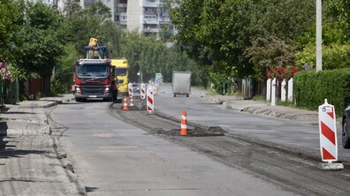 Частина вул. Шевченка, де тривають ремонтні роботи. Старий шар асфальту вже зрізали, місце ремонту огороджене помаранчевими конусами. Назустріч рухається ремонтна техніка, а в напрямку Рясного їде вантажівка.