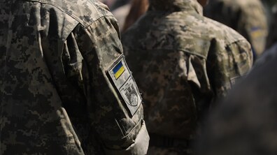 Українські військовослужбовці у формі, на рукаві одного з них видно український прапор і шеврон.