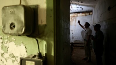 Двоє людей в непрацюючому приміщенні великого сховища на підприємстві. Перший заступник міського голови Львова освічує приміщення ліхтариком. Довкола видно подекуди оббиту радянську плитку, ржаві труби. На стіні поруч з дверима облізла зелена фарба.