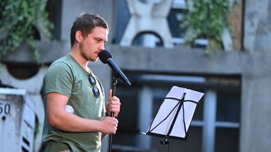 у дворику Ратуші львівський актор декламує уривок з вистави, яку написав ветеран