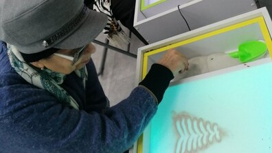 Фото: Літні панянки разом з дітьми малювали піском казкових героїв