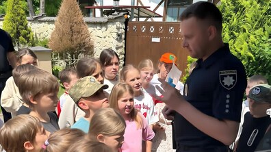 Поліцейський щось пояснює дітям