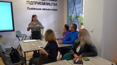 Лекторка бізнес-школи щось пояснює слухачам