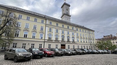 Автомобілі, які передали волонтери норвезької ініціативи Ukrainian Freedom Convoys, стоять на площі Ринок у Львові. Авто припарковані один біля одного в один ряд. Позаду видно будівлю міської Ратуші.