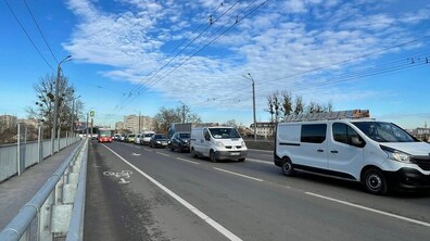 На оновленому шляхопроводі на вулиці Сяйво видно відокремлену велосипедну смугу, позначену піктограмою. По автомобільних смугах курсує транспорт.