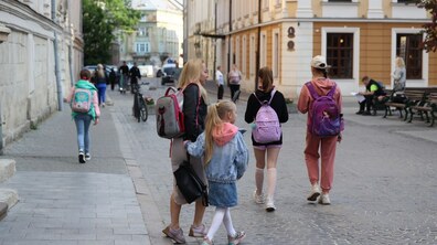 Школярі з батьками ідуть по вулиці