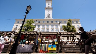 Знизу видно ятки представників ветеранського бізнесу. Позаду красується башня міської Ратуші.