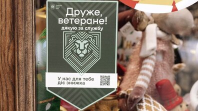 На вітрині сувенірної крамниці “Крам” висить наліпка із написом «Друже ветеране, дякую за службу. У нас для тебе знижка»