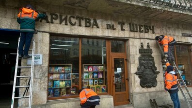 Фото: У центрі Львова демонтували історичну вивіску книгарні для реставрації