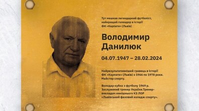 На меморіальній таблиці зображений Володимир Данилюк у білій сорочці. На таблиці зазначено інформація з дато народження і смерті