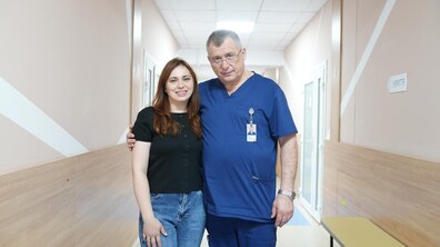 Пацієнтка Ганна та її лікар – щелепно-лицевий хірург Олег Ковтуняк стоять у холі лікарні. Обоє дивляться в камеру й усміхаються.