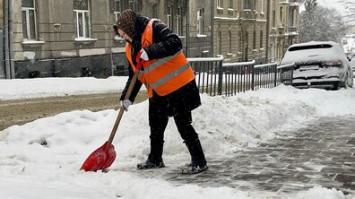 двірник прибирає засніжену вулицю Львова
