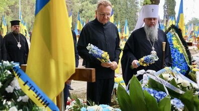 Митрополит Епіфаній та міський голова Львова Андрій Садовий тримають квіти на полі Почесних поховань № 87.