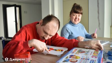 Люди з інвалідністю сидять за столом