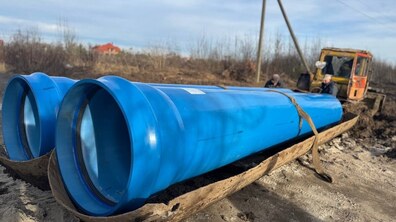 дві великі поліетиленові труби синього кольору, які прокладають у с. Бартатові